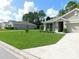 Neat front yard with lush green lawn, landscaping, and a paved walkway to the home's entrance at 80 Hickory Course Loop, Ocala, FL 34472