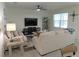 Cozy living room with neutral tones, a ceiling fan, and a large window offering plenty of natural light at 80 Hickory Course Loop, Ocala, FL 34472