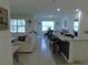 Bright living space featuring an open layout with tile floors, seamless flow to the kitchen, and ample natural light at 80 Hickory Course Loop, Ocala, FL 34472