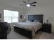 Spacious main bedroom with large window, ceiling fan, and elegant dark-toned furniture at 80 Hickory Course Loop, Ocala, FL 34472