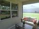 The screen porch has a cozy seating arrangement and a view of the backyard through large windows at 80 Hickory Course Loop, Ocala, FL 34472