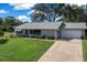 An elevated shot of a cozy home with a well-kept lawn and driveway leading to a two-car garage at 8461 Sw 109Th St, Ocala, FL 34481