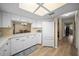An open kitchen with white cabinets, light countertops, and wood-look flooring at 8461 Sw 109Th St, Ocala, FL 34481