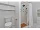 Bathroom features tiled shower, glass block window, and toilet with white cabinets at 8775 Sw 192 Ct, Dunnellon, FL 34432