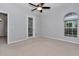 Bedroom with neutral carpet, ceiling fan, and door to outdoor space at 8775 Sw 192 Ct, Dunnellon, FL 34432