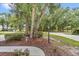 Landscaped front yard featuring mature trees, green bushes, and fresh mulch at 8775 Sw 192 Ct, Dunnellon, FL 34432