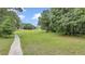 Expansive green grounds and mature trees with a walking path provide a tranquil setting at 8775 Sw 192 Ct, Dunnellon, FL 34432