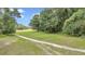 Expansive green grounds and mature trees with a walking path provide a tranquil setting at 8775 Sw 192 Ct, Dunnellon, FL 34432