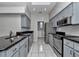 Galley kitchen features gray cabinets, subway tile backsplash, and stainless steel appliances at 8775 Sw 192 Ct, Dunnellon, FL 34432