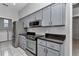 A kitchen features gray cabinets, subway tile backsplash, and stainless steel appliances at 8775 Sw 192 Ct, Dunnellon, FL 34432