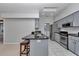 A kitchen features gray cabinets, a breakfast bar and stainless steel appliances at 8775 Sw 192 Ct, Dunnellon, FL 34432