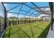 Spacious backyard featuring a screened-in lanai, lush lawn, and partial views of the neighborhood at 8913 Sw 76Th Ln, Ocala, FL 34481