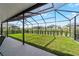 View of the backyard from the screened lanai with well-maintained lawn and privacy landscaping at 8913 Sw 76Th Ln, Ocala, FL 34481
