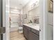 Modern bathroom with gray vanity, shower-tub combo, and wood-look floors at 8913 Sw 76Th Ln, Ocala, FL 34481