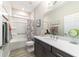 Modern bathroom with gray vanity, shower-tub combo, and wood-look floors at 8913 Sw 76Th Ln, Ocala, FL 34481