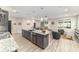 Open kitchen featuring a granite island, stainless steel appliances, and a view of the adjacent living area at 8913 Sw 76Th Ln, Ocala, FL 34481