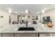 Granite countertop island sink with a view of the dining and living rooms in this modern home at 8913 Sw 76Th Ln, Ocala, FL 34481