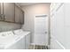 Laundry room with washer and dryer, gray cabinets, and wood-look floors at 8913 Sw 76Th Ln, Ocala, FL 34481
