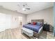 Bright main bedroom with gray walls, blue bedding, ceiling fan, and view into the main bathroom at 8913 Sw 76Th Ln, Ocala, FL 34481