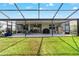 Spacious screened-in patio featuring an outdoor dining area and a well-maintained lawn at 8913 Sw 76Th Ln, Ocala, FL 34481