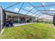 Large screened-in patio with seating and grill overlooking the manicured backyard at 8913 Sw 76Th Ln, Ocala, FL 34481