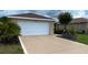 Spacious driveway leading to a two-car garage, complemented by lush greenery at 9047 Sw 102Nd Cir, Ocala, FL 34481