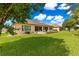 Beautiful backyard featuring mature trees, manicured landscaping, lush lawn, and a paver patio area at 9120 Se 125Th Loop, Summerfield, FL 34491