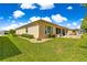 Expansive backyard featuring a stone patio with ample seating, screened in lanai, and lush green lawn at 9120 Se 125Th Loop, Summerfield, FL 34491