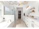 Bright bathroom features a soaking tub, glass shower, double vanity, walk-in closet, and colorful ceiling at 9120 Se 125Th Loop, Summerfield, FL 34491