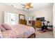 Bright bedroom features an ensuite bathroom, wood-look flooring, and a ceiling fan at 9120 Se 125Th Loop, Summerfield, FL 34491
