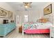 Bright bedroom with a queen bed, colorful bedding, a ceiling fan and wood-look floors at 9120 Se 125Th Loop, Summerfield, FL 34491