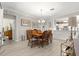 Well-lit dining area features a chandelier, artwork, and open access to the kitchen at 9120 Se 125Th Loop, Summerfield, FL 34491