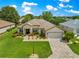 Beautiful single-story home with a manicured lawn, paver driveway, and attached two car garage at 9120 Se 125Th Loop, Summerfield, FL 34491
