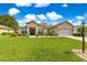 Charming single-story home with a well-manicured lawn and inviting curb appeal under sunny blue skies at 9120 Se 125Th Loop, Summerfield, FL 34491