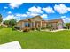 Beautifully landscaped home with green lawn, mature shrubs, and a two-car garage and ample natural light at 9120 Se 125Th Loop, Summerfield, FL 34491