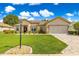 Charming single-story home with a well-manicured lawn and inviting curb appeal under sunny blue skies at 9120 Se 125Th Loop, Summerfield, FL 34491