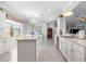 Well-lit kitchen features an island, pendant lighting, white cabinets, and modern appliances at 9120 Se 125Th Loop, Summerfield, FL 34491