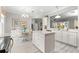 Bright kitchen features an island, pendant lighting, white cabinets, and stainless steel appliances at 9120 Se 125Th Loop, Summerfield, FL 34491