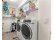 Functional laundry room area features a washer and dryer set with built-in storage shelves at 9120 Se 125Th Loop, Summerfield, FL 34491