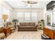 Inviting living room featuring plantation shutters, modern furnishings, and neutral tones at 9120 Se 125Th Loop, Summerfield, FL 34491