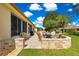 Well-designed patio area with a stone fire pit, plenty of seating, screened in lanai, and landscaping at 9120 Se 125Th Loop, Summerfield, FL 34491