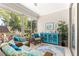 Relaxing sunroom with wicker furniture, colorful cushions, and lush greenery at 9120 Se 125Th Loop, Summerfield, FL 34491