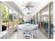 Bright sunroom featuring a white dining table, large windows, and serene outdoor views at 9120 Se 125Th Loop, Summerfield, FL 34491