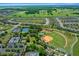 An aerial view showing the community baseball field, tennis courts and the residential neighborhood at 9948 Sw 69Th Ln, Ocala, FL 34481