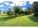 Expansive backyard with a well-maintained lawn and a view of the home's sunroom at 9948 Sw 69Th Ln, Ocala, FL 34481