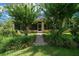 Backyard view showcasing lush landscaping and a charming brick pathway to the home's entrance at 9948 Sw 69Th Ln, Ocala, FL 34481