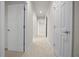Bright hallway featuring tile flooring and white doors leading to various rooms at 9948 Sw 69Th Ln, Ocala, FL 34481