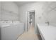 Spacious laundry area featuring a sink, storage shelves, and a modern washer and dryer at 9948 Sw 69Th Ln, Ocala, FL 34481