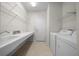 Well-equipped laundry room with a sink, shelving, washer, and dryer at 9948 Sw 69Th Ln, Ocala, FL 34481