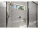 Shower stall featuring bench, hand-held shower head and small window at 9948 Sw 69Th Ln, Ocala, FL 34481